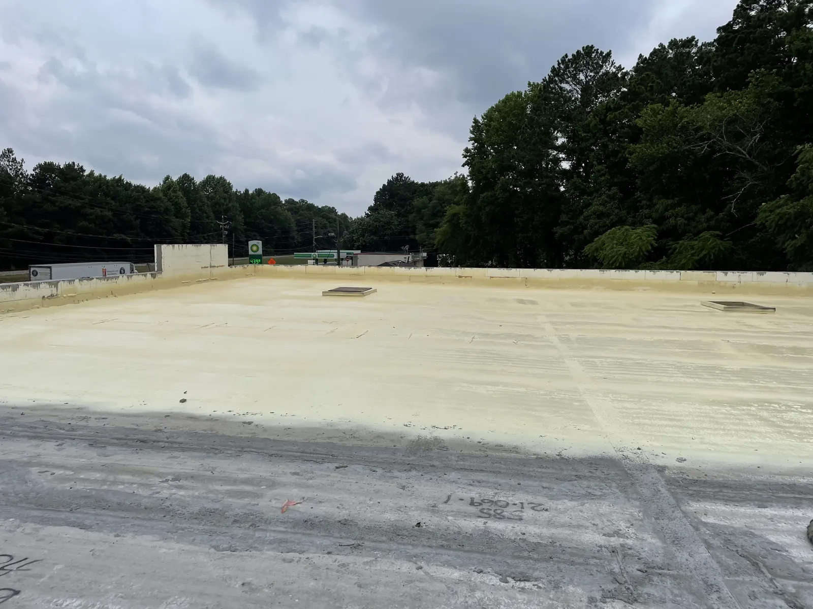 Spray foam applied across a large flat commercial roof, viewed from the roof surface