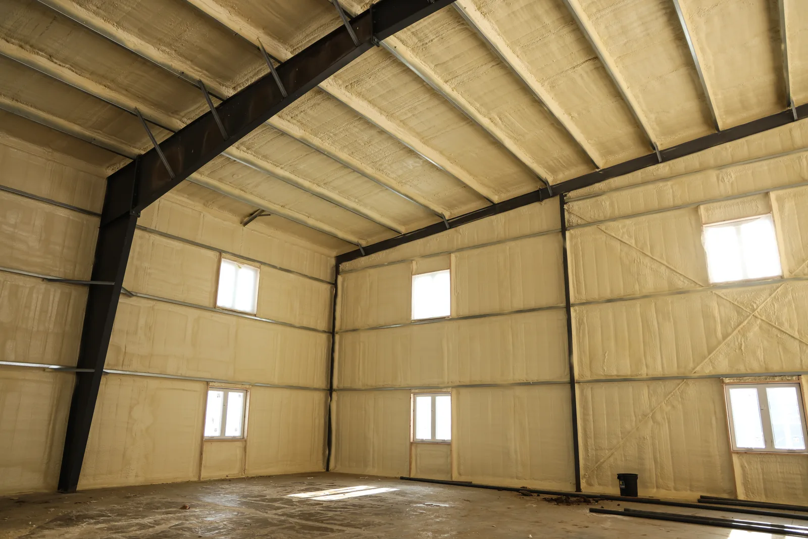 Steel-framed pole barn with spray foam covering the full height of the walls and the underside of the roof.